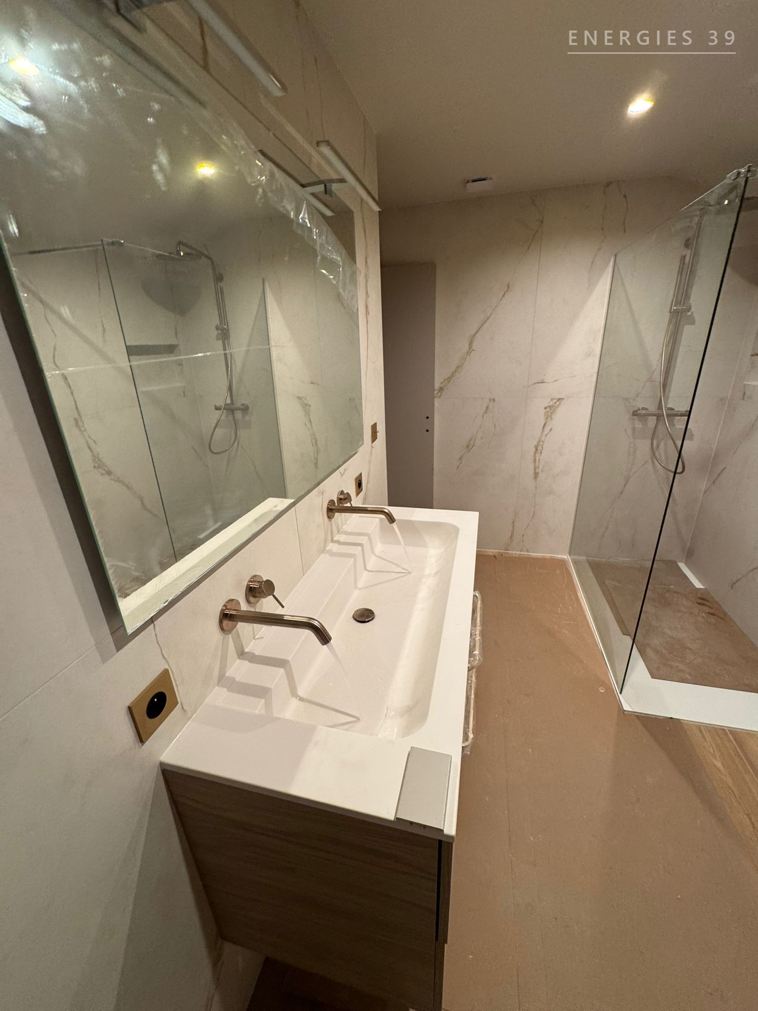 Salle de bain en marbre clair avec douche italienne